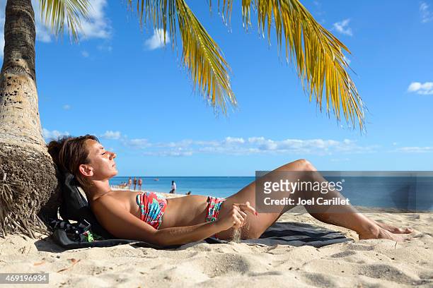 woman visiting cuba sunbathing on beach at playa ancon - playa ancon stock pictures, royalty-free photos & images