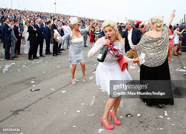 Racegoer drinks from a bottle of Champagne as she attends day 2 'Ladies Day' of the Crabbie's Grand National Festival at Aintree Racecourse on April...