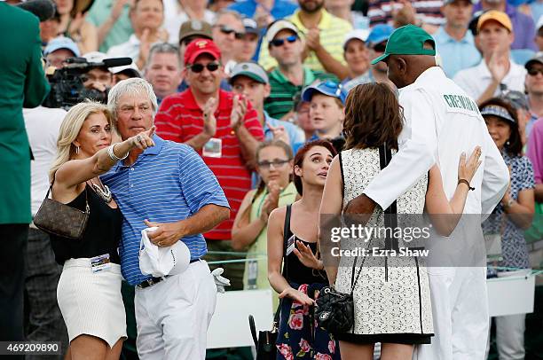 Ben Crenshaw of the United States waits alongside his wife Julie, their daughters and longtime caddie Carl Jackson behind the 18th green after...