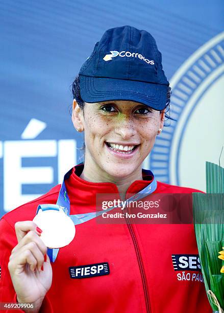 Gold medal winner Daynara de Paula celebrates on the podium after the swimming of Women's 50m butterfly finals on day 5 of the Maria Lenk Swimming...