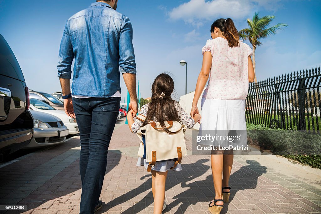 Young family taking daughter to school