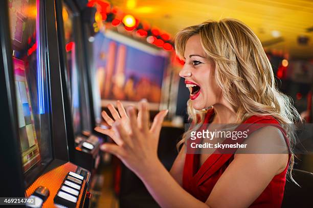 preisgekrönten verzückt frau im casino auf spielautomaten. - casino win stock-fotos und bilder