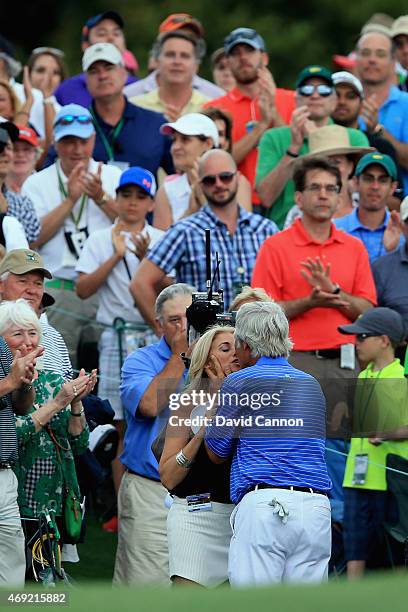 Ben Crenshaw of the United States kisses his wife Julie behind the 18th green after playing his final Masters during the second round of the 2015...