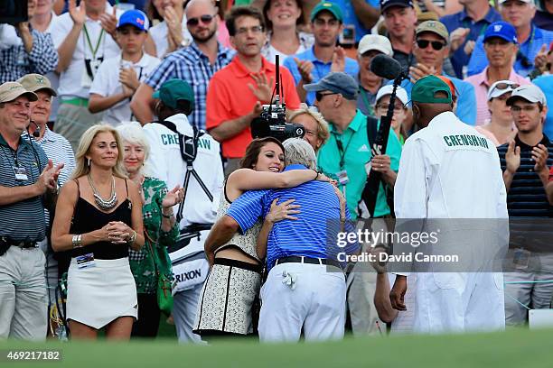 Ben Crenshaw of the United States is greeted by his wife Julie and their daughters behind the 18th green after playing his final Masters during the...