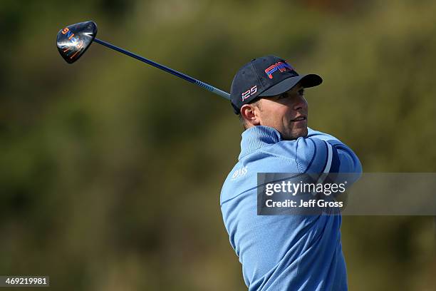 Luke Guthrie watches his shot in the first round of the Northern Trust Open at the Riviera Country Club on February 13, 2014 in Pacific Palisades,...