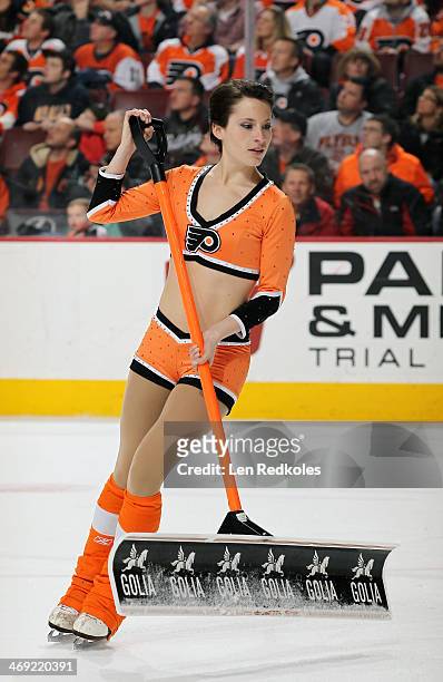 Kelsey Hoffman of the Philadelphia Flyers ice girls cleans the ice during a timeout against the Calgary Flames on February 8, 2014 at the Wells Fargo...