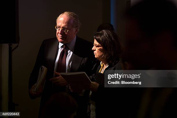 Paolo Scaroni, chief executive officer of Eni SpA, left, leaves the stage after a news conference following the company's 2014-2017 strategy...