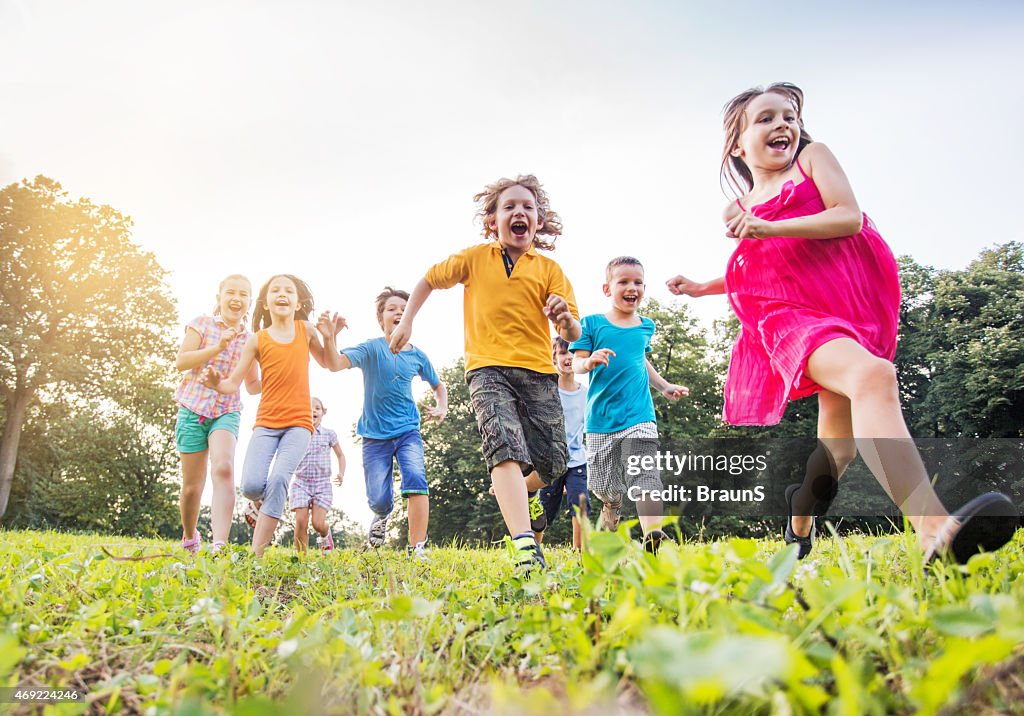 Below view of happy children running in the park.