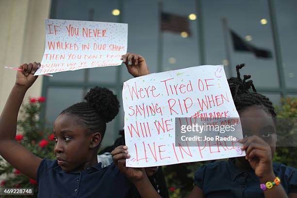 London Simmions and Nevaeh Purcell hold signs at a vigil in front of the North Charleston City Hall for Walter Scott on April 10, 2015 in North...