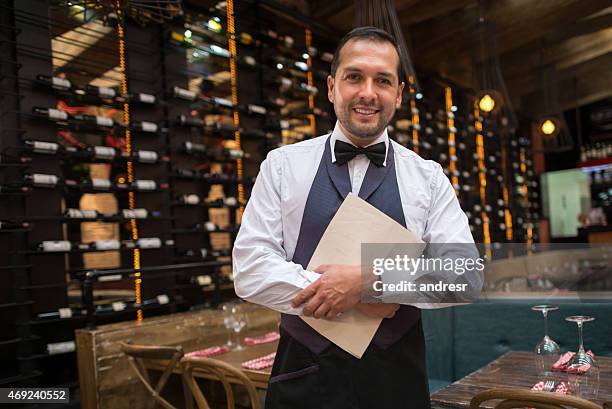 waiter holding menu at a restaurant - hostesses stockfoto's en -beelden