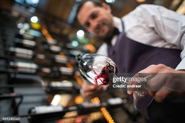 sommelier pouring a glass of wine - sommelier stockfoto's en -beelden