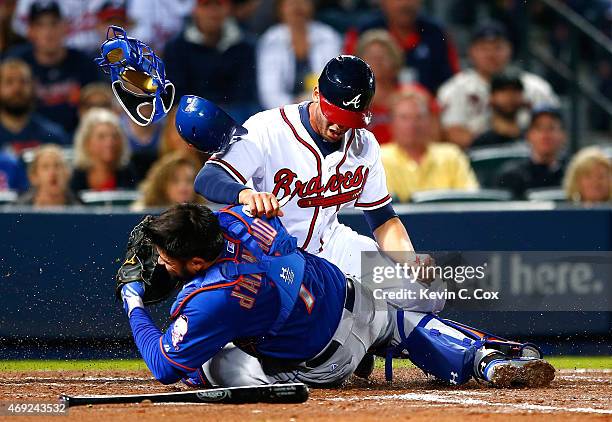 Andrelton Simmons of the Atlanta Braves collides with Travis d'Arnaud of the New York Mets as he is tagged out at homeplate in the second inning...