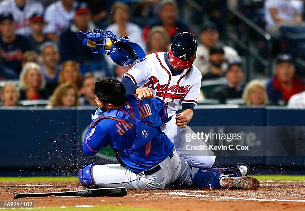 Andrelton Simmons of the Atlanta Braves collides with Travis d'Arnaud of the New York Mets as he is tagged out at homeplate in the second inning...