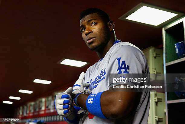 Yasiel Puig of the Los Angeles Dodgers puts on his batting gloves in the dugout during the MLB game against the Arizona Diamondbacks at Chase Field...