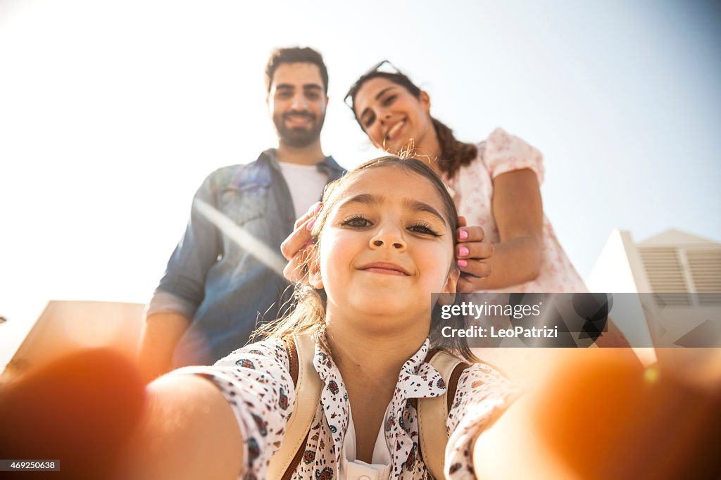 Girl taking a selfie with parents