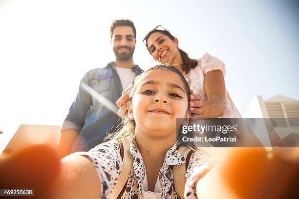girl taking a selfie with parents - emirati couple stock pictures, royalty-free photos & images
