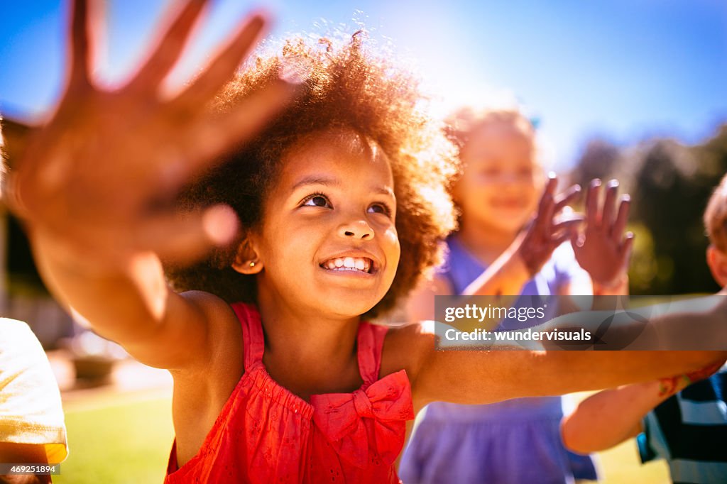 Sonriendo poco Afro girl holding feliz con las manos