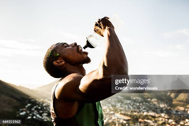 durst afrikanischen amerikanischen sportler trinkwasser mit weiten m - open workouts stock-fotos und bilder