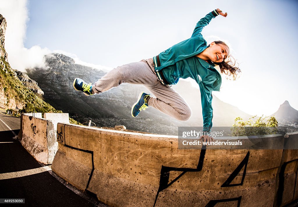 Breakdancer voller Vitalität springt über die Mauer parkour- Stil