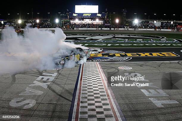 Erik Jones, driver of the GameStop/Mortal Kombat X Toyota, celebrates with a burnout after winning the NASCAR XFINITY Series O'Reilly Auto Parts 300...