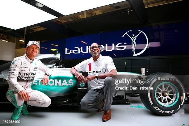 Nico Rosberg of Germany and Mercedes GP poses with Laureus Sport for Good Foundation Chairman Edwin Moses next to the F1 W06 in the team garage...