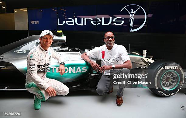 Nico Rosberg of Germany and Mercedes GP poses with Laureus Sport for Good Foundation Chairman Edwin Moses next to the F1 W06 in the team garage...