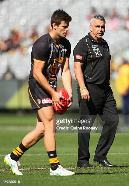 Mark Williams the assistant coach of the Tigers talks to Trent Cotchin as he warms up during the round two AFL match between the Richmond Tigers and...