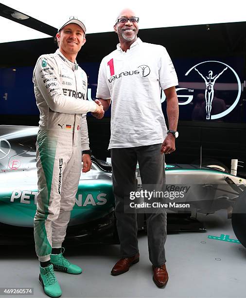 Nico Rosberg of Germany and Mercedes GP poses with Laureus Sport for Good Foundation Chairman Edwin Moses next to the F1 W06 in the team garage...