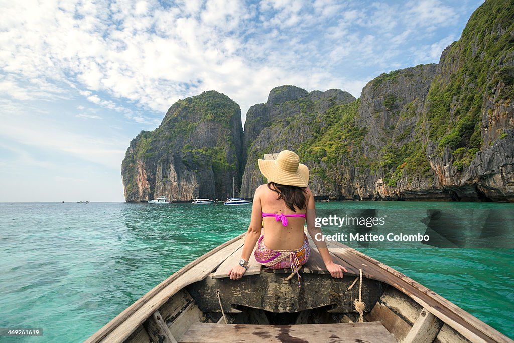 Woman sitting on long tail boat's prow, Thailand