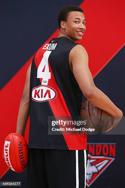 Young Australian basketball player Dante Exum poses with his jumper presented to him by Joe Daniher of the Bombers during an Essendon Bombers AFL...