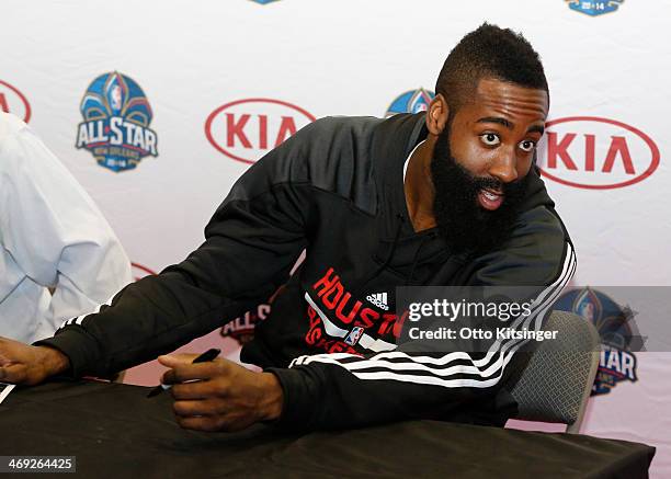 James Harden of the Houston Rockets talks to a fan in line while signing autographs at the Kia MVP Court during the 2014 NBA All-Star Jam Session at...