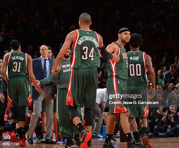 Giannis Antetokounmpo of the Milwaukee Bucks shakes hands with Jared Dudley during a timeout against the New York Knicks at Madison Square Garden on...