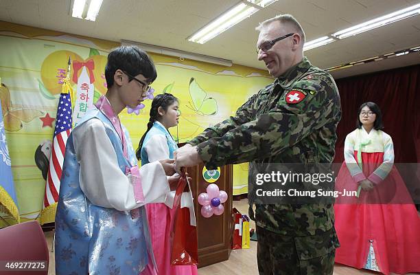 Graduate of Taesungdong Elementary School Kwon Jong-Hyuk recieves a present from COL. Jorgensen, Swiss delegation of the Neutral Nations Supervisory...
