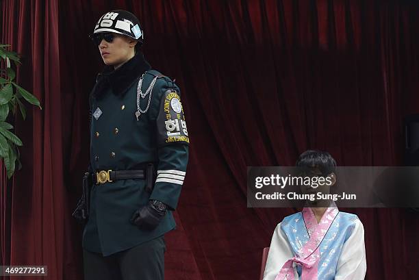 Graduate of Taesungdong Elementary School Kwon Jong-Hyuk the graduation ceremony as a South Korean soldier escorts on February 14, 2014 in...