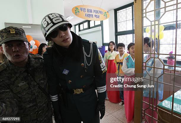 Graduate of Taesungdong Elementary School students attend as a South Korean soldiers escort them during the graduation ceremony on February 14, 2014...