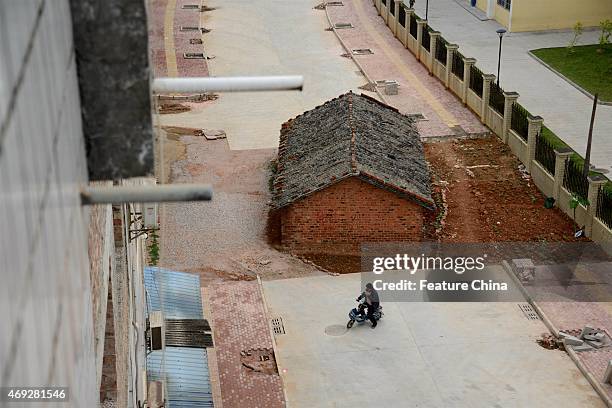 Nail' house blocks the road almost completely outside a residential block on April 10, 2015 in Nanning, South China. 'Nail' houses usually refer to...