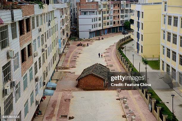 Nail' house blocks the road almost completely outside a residential block on April 10, 2015 in Nanning, South China. 'Nail' houses usually refer to...