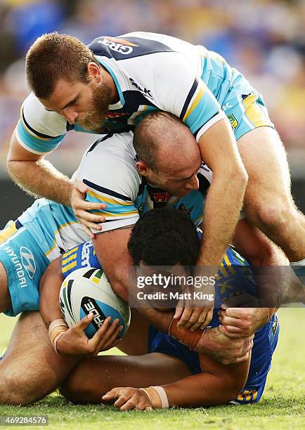 Bureta Faraimo of the Eels is tackled by Matt White and Ryan Simpkins of the Titans during the round six NRL match between the Parramatta Eels and...