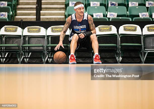 Texas Legends basketball player Delonte West dribbles a basketball in a sitting position while watching a pregame dance routine performed by local...