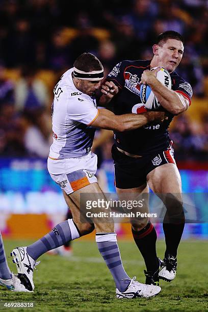Jacob Lillyman of the Warriors fends off Robbie Farah of the Tigers during the round six NRL match between the New Zealand Warriors and the Wests...