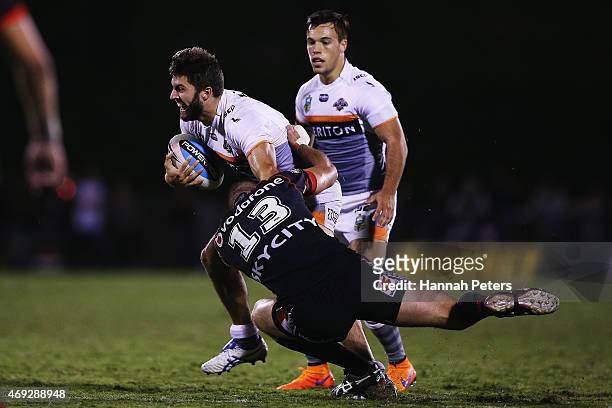 James Tedesco of the Tigers fends off Simon Mannering of the Warriors during the round six NRL match between the New Zealand Warriors and the Wests...