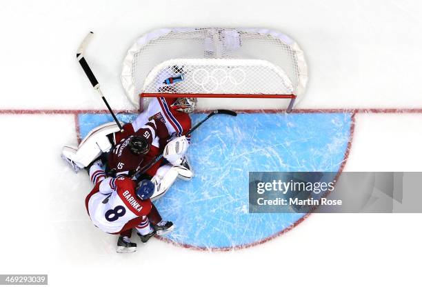 Martins Karsums of Latvia gets tangled up with Michal Barinka and Ondrej Pavelec of Czech Republic in front of the net in the second period during...