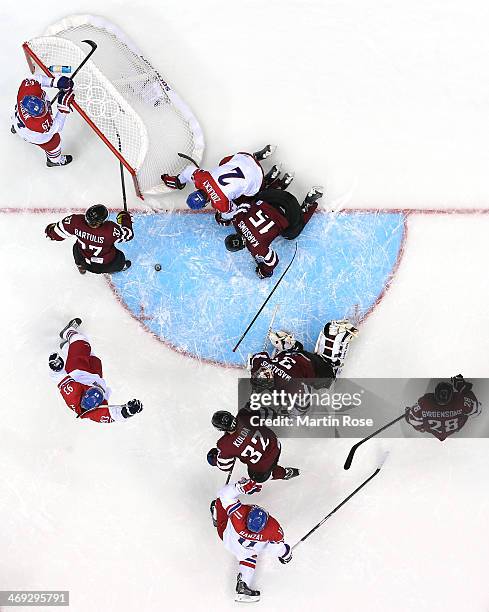 Marek Zidlicky of Czech Republic scores while being hit into the net by Martins Karsums of Latvia as Edgars Masalskis looks on in the second period...