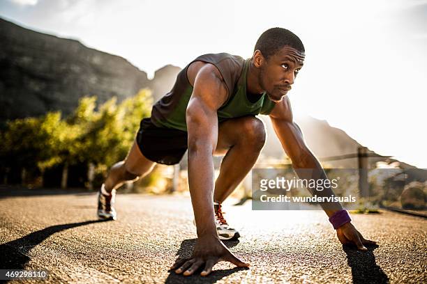 fit african american athlete in a starting position - morning stretch stock pictures, royalty-free photos & images