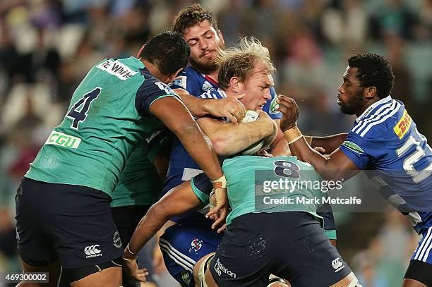 Schalk Burger of the Stormers is tackled by Wycliff Palu and Will Skelton of the Waratahs during the round nine Super Rugby match between the...