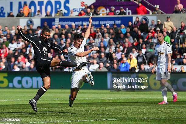 Aaron Lennon of Everton scores the first goal past Jack Cork of Swansea City during the Barclays Premier League match between Swansea City and...