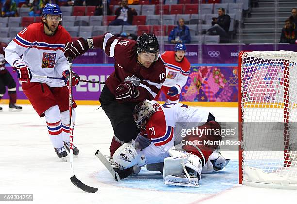 Kaspars Daugavins of Latvia collides with Ondrej Pavelec of Czech Republic in the third period during the Men's Ice Hockey Preliminary Round Group C...