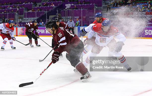 Kaspars Daugavins of Latvia handles the puck against Tomas Kaberle of Czech Republic in the third period during the Men's Ice Hockey Preliminary...