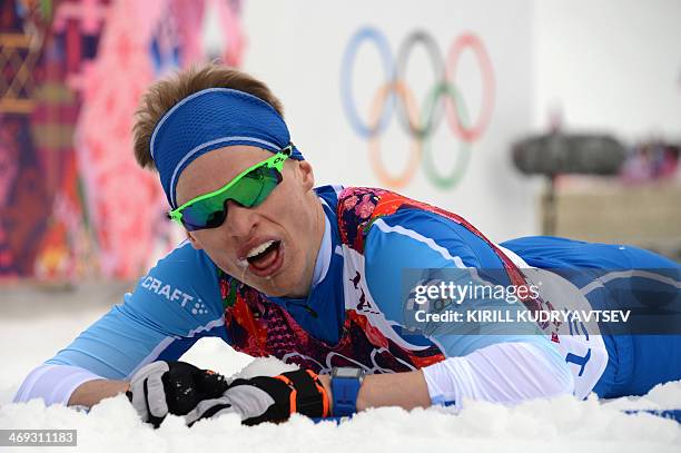 Finland's Iivo Niskanen lies on the snow at the finish line of the Men's Cross-Country Skiing 15km Classic at the Laura Cross-Country Ski and...