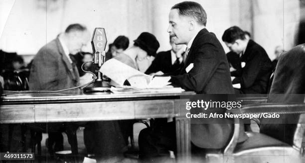 Walter White, activist and Secretary of NAACP, at a table with microphone for NBC, February 24, 1934.
